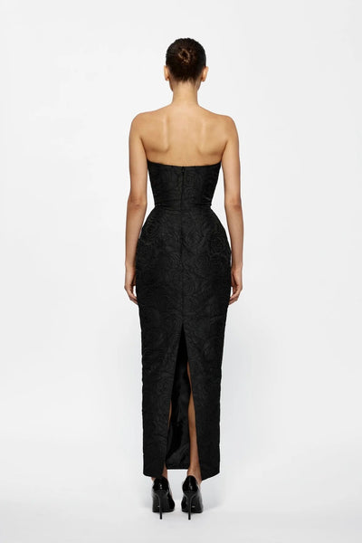 Black strapless gown with a high slit on a white background